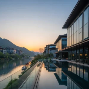 Architettura moderna di un resort di lusso a Hangzhou, Cina, con vista su un fiume e montagne, al tramonto.