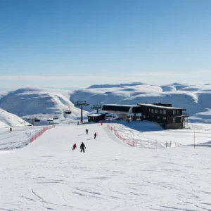 Sciatori sulla neve con un moderno resort e impianti di risalita sullo sfondo in Lesotho
