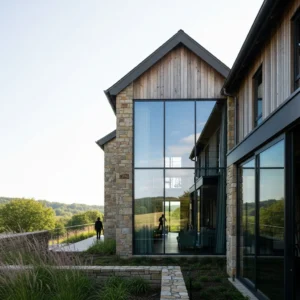 Architettura moderna e lussuosa del Resort MIYA LOSTVILLA Huchen Barn, con ampie vetrate che si affacciano su un paesaggio naturale rigoglioso.