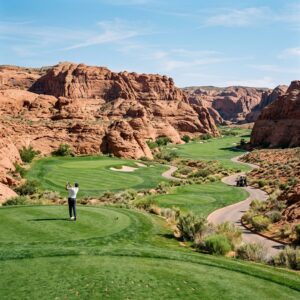 Vista panoramica di un campo da golf lussuoso con fairway verdi e formazioni rocciose rosse presso il Black Desert Resort. (Immagine generata con IA)