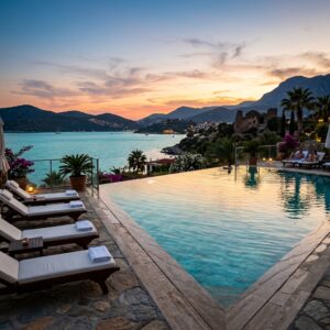 Piscina a sfioro di un resort di lusso con vista sul mare e sulla costa turca al tramonto. (Immagine generata con IA)