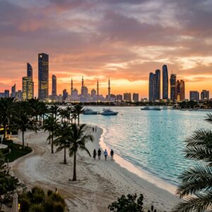 Panorama di Abu Dhabi al tramonto, con la Grande Moschea Sheikh Zayed e la skyline moderna, e la spiaggia di un resort di lusso.