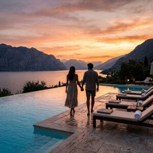 Piscina a sfioro di un resort di lusso sul Lago di Garda, con vista sulle montagne e una coppia di spalle in lontananza.